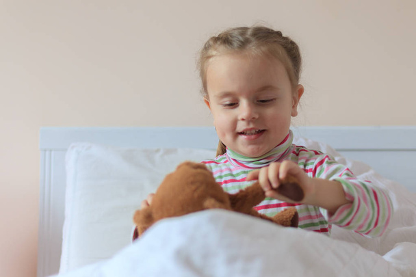 malá holčička drží medvídka - Fotografie, Obrázek