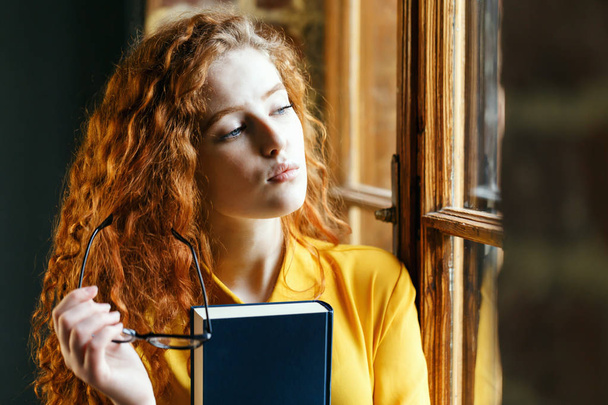 Ginger Girl Holding Book and Glasses - Fotoğraf, Görsel