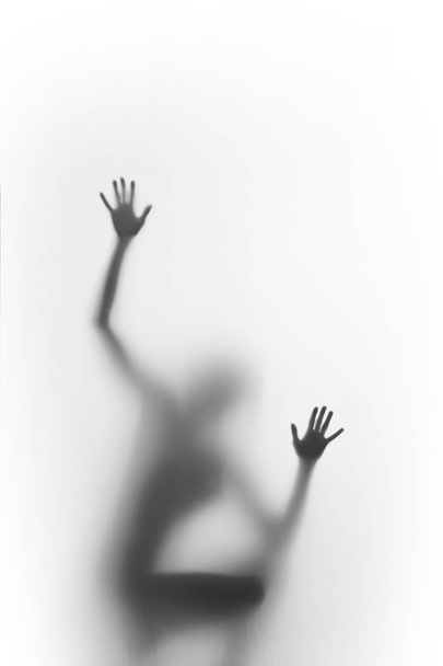 Woman squatter, and climb. Human body silhouette can be seen blurred behind a diffuse surface, only hands, palms and fingers are sharp.  - Fotoğraf, Görsel