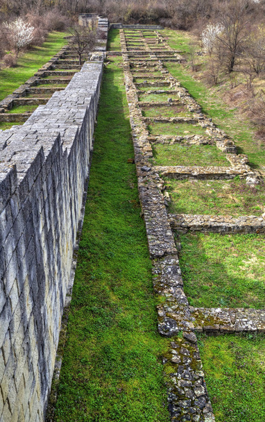Συμπαγές πέτρινο τοίχο και τα ερείπια του αρχαίου φρουρίου - Φωτογραφία, εικόνα