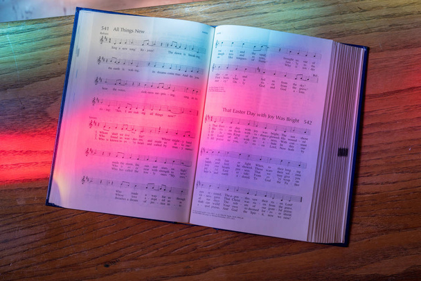 Luz da janela de vidro manchado cai no livro de música aberta na igreja americana
 - Foto, Imagem