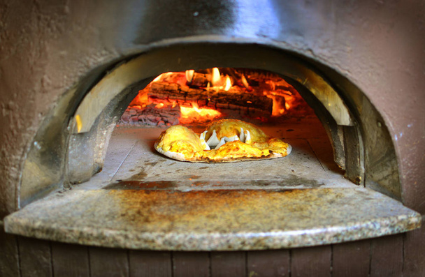 Italian pizza preparing in wood-fired oven - Photo, Image