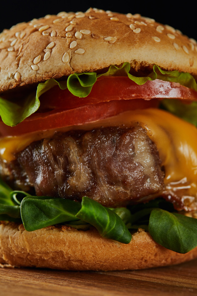 close up of delicious meat burger with cheese, greenery and tomatoes  - Photo, Image