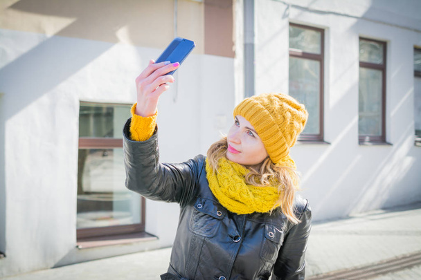 portrait of an attractive woman taking selfie on city streets - Fotoğraf, Görsel