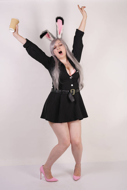 cute plus size plump girl with rabbit fur ears yawning so sweet on white studio background - Photo, Image