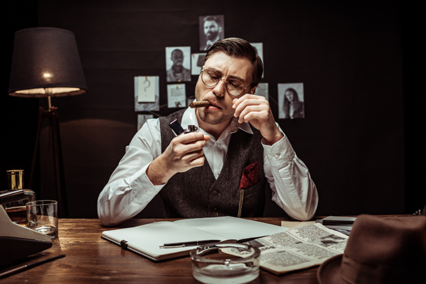 Detective in glasses and white shirt lighting cigar in dark office - Foto, Bild