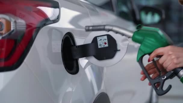 Vrouw vult benzine in haar auto bij een benzinestation closeup - Video