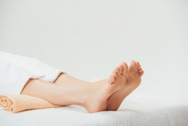 partial view of adult woman lying on beige towel in spa  - Fotografie, Obrázek