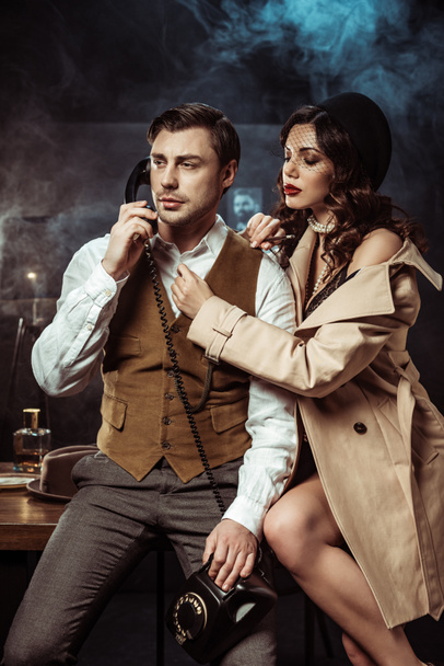 Sexy woman in lingerie and trench coat seducing detective in office - Φωτογραφία, εικόνα