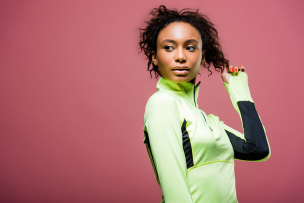 beautiful african american sportswoman in track jacket posing isolated on pink with copy space - Foto, Imagen