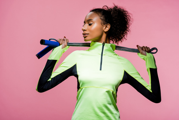 beautiful african american sportswoman posing with skipping rope isolated on pink - Foto, immagini