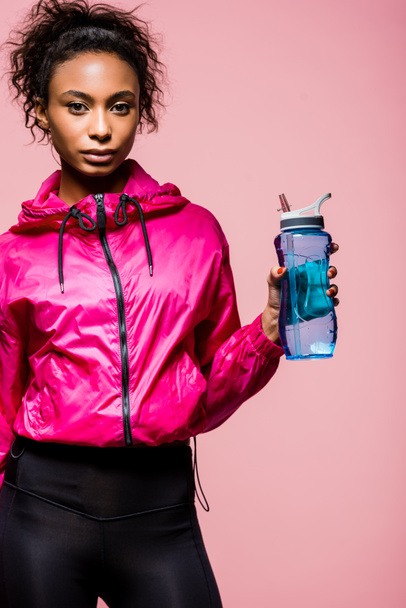 szép afro-amerikai sportoló sport üveg látszó-on fényképezőgép pink elszigetelt - Fotó, kép