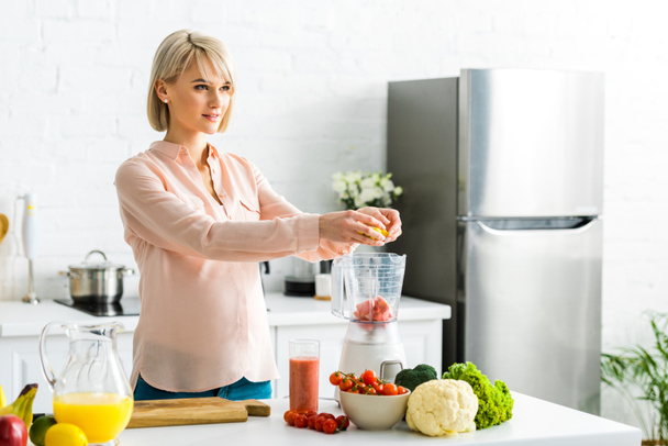  blonde pregnant young woman preparing food in kitchen  - 写真・画像