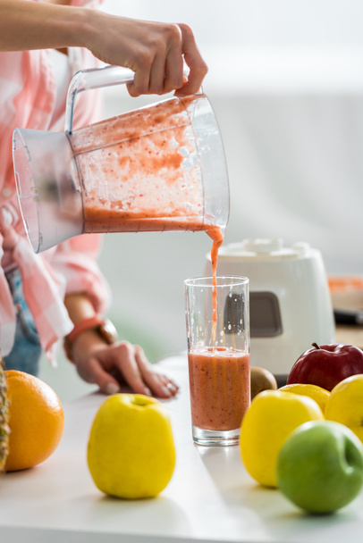 cropped view of young woman pouring tasty smoothie in glass   - Photo, Image