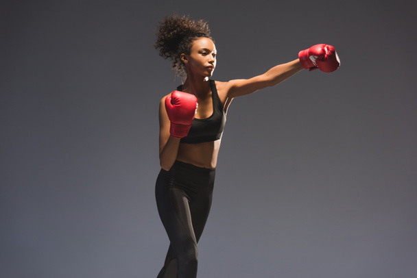 beautiful athletic african american sportswoman boxing isolated on black with copy space - 写真・画像