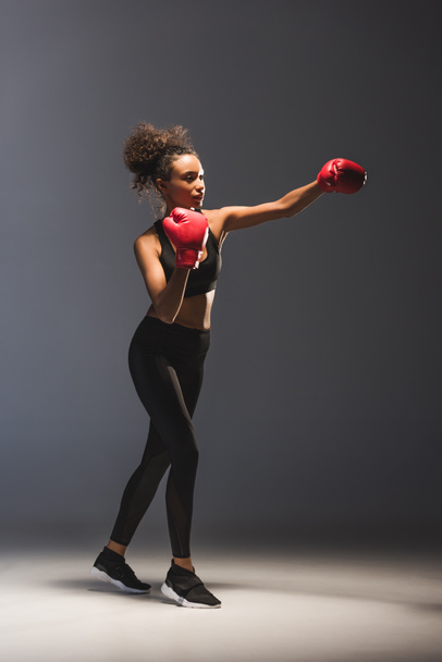 beautiful athletic african american sportswoman boxing on black - Fotoğraf, Görsel