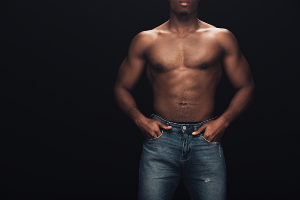 partial view of sexy muscular african american man in denim posing isolated on black with copy space - 写真・画像