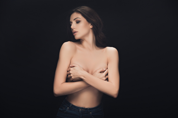 beautiful sensual girl covering breasts with hands and posing isolated on black - Foto, immagini