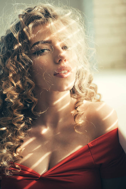 Female glamour face with long blonde hairstyle. Beautiful woman with curly hair and perfect makeup. - Фото, зображення