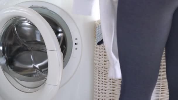 女性は洗濯機で洗濯を読み込みます - 映像、動画