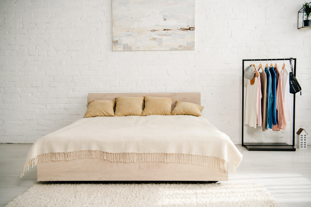 Kevyt makuuhuone iso sänky, matto ja suora teline
 - Valokuva, kuva