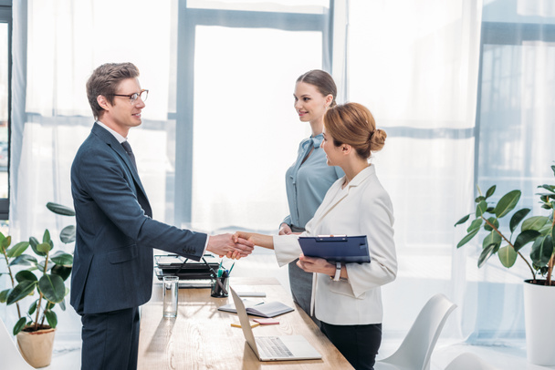 happy employee shaking hands with recruiter on job interview  - Photo, Image