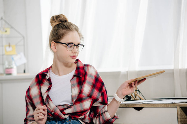Teenager in glasses and red checkered shirt holding book - Foto, Imagem