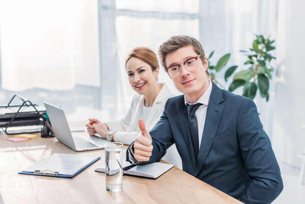 handsome recruiter in glasses showing thumb up near cheerful coworker  - Photo, image