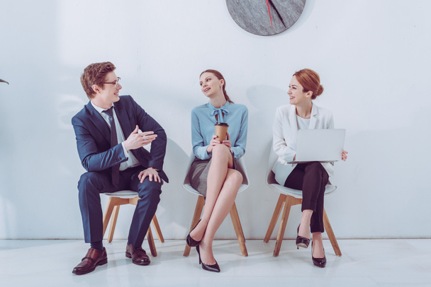 cheerful man in glasses talking with attractive women waiting job interview  - Valokuva, kuva