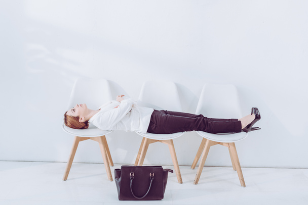 empregado atraente deitado em cadeiras enquanto espera entrevista de emprego
  - Foto, Imagem
