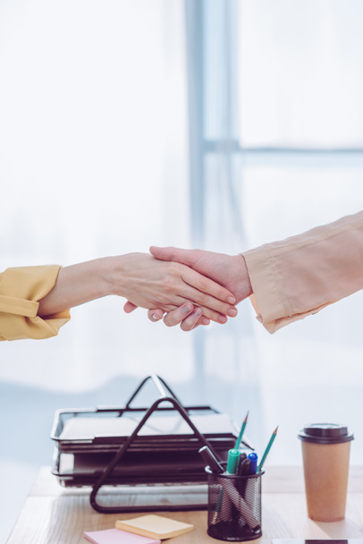 cropped view of recruiter and female employee shaking hands in office  - Photo, Image