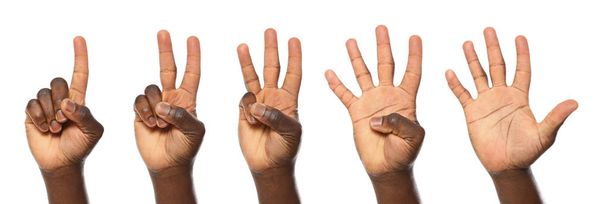Hombre afroamericano mostrando diferentes gestos sobre fondo blanco, vista de cerca de las manos
 - Foto, Imagen