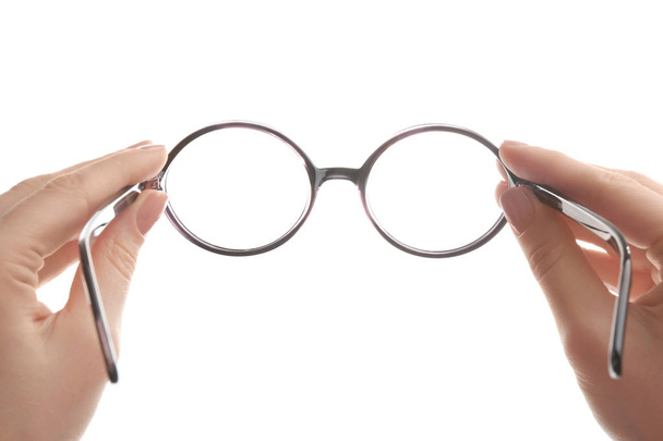 Female ophthalmologist holding glasses on white background, closeup - Photo, Image