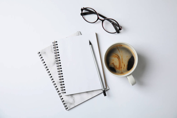 Notebooks with glasses and coffee on white background, top view - Photo, image