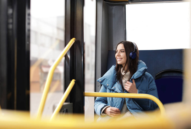 Young woman listening to music with headphones in public transport - Photo, image