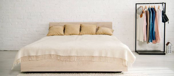 Cama grande con cojines y manta en dormitorio adolescente
 - Foto, Imagen
