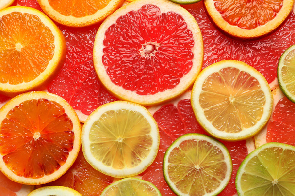 Slices of fresh citrus fruits as background, top view - 写真・画像