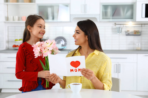 Daughter congratulating her mom in kitchen. Happy Mother's Day - Foto, immagini