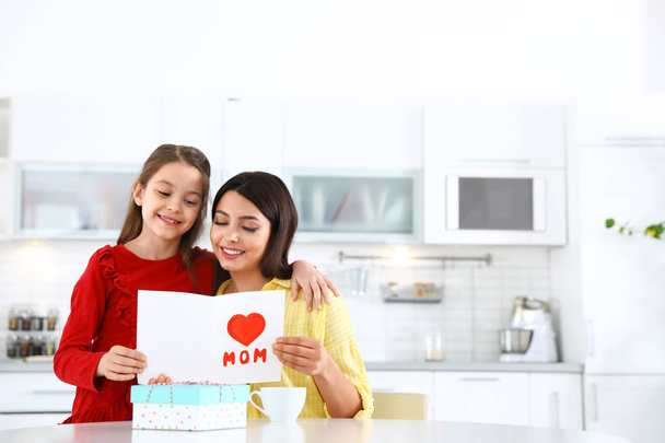 Daughter congratulating her mom in kitchen, space for text. Happy Mother's Day - Foto, afbeelding