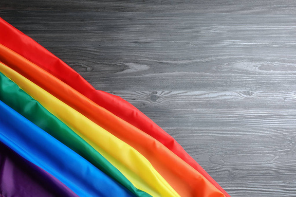 Bright rainbow gay flag on wooden background, top view with space for text. LGBT community - Fotó, kép