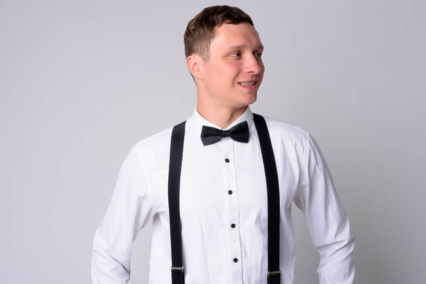 Portrait of happy young businessman with suspenders thinking - Photo, image