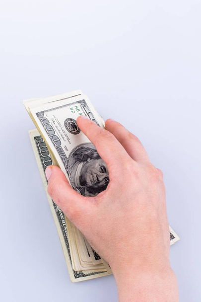 Human hand holding American dollar banknotes on white background - Photo, Image