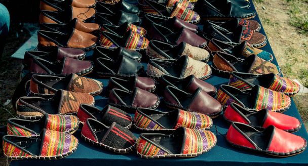 Набір традиційного шкіряного взуття ручної роботи на базарі
  - Фото, зображення