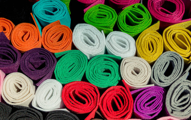 Decenas de rollos de tela de colores en exhibición
 - Foto, Imagen