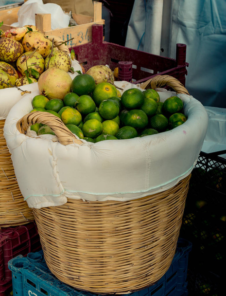Green mandarins in a straw basket on display - Zdjęcie, obraz