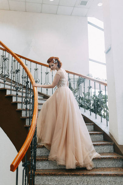 La mariée est dans un hôtel cher dans les escaliers. Séance photo de mariage dans une belle robe
. - Photo, image