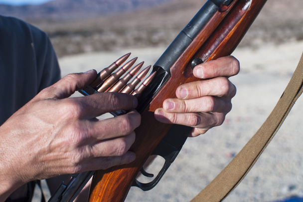 Cargando munición en un rifle
 - Foto, Imagen