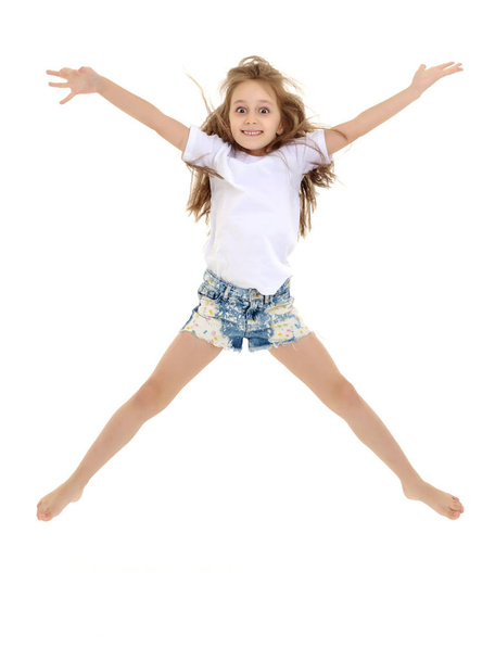 A little girl in a pure white t-shirt is jumping. The concept of - Zdjęcie, obraz