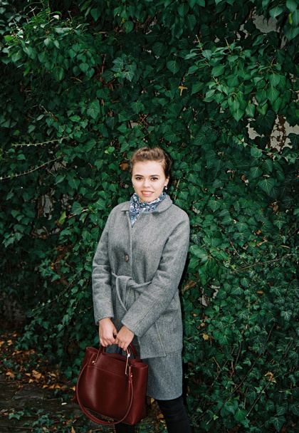 Photo on film. Girl in the background of green ivy. - Valokuva, kuva