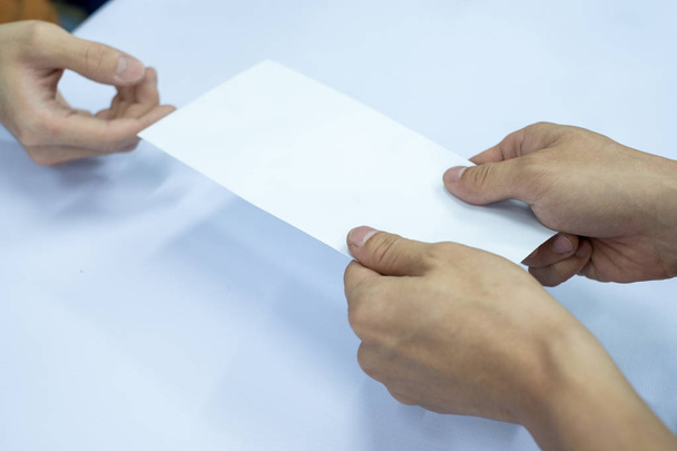 Рука бізнесмен дає порожній білий конверт
 - Фото, зображення